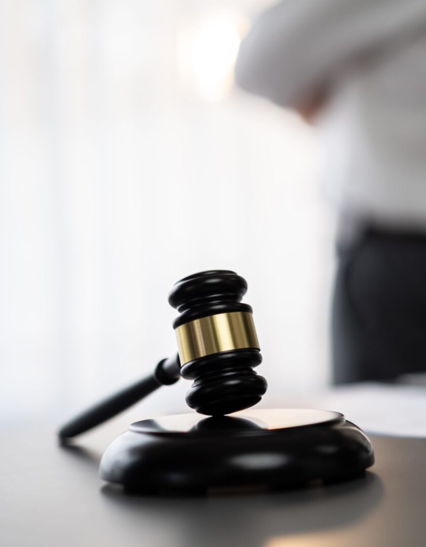 Judge's gavel on a table, blurred background.